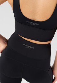 Melns ribots sporta krūšturis un augsta vidukļa legingi no even&odd Active. Raksturīgas logotipa detaļas un gluda, elastīga auduma.