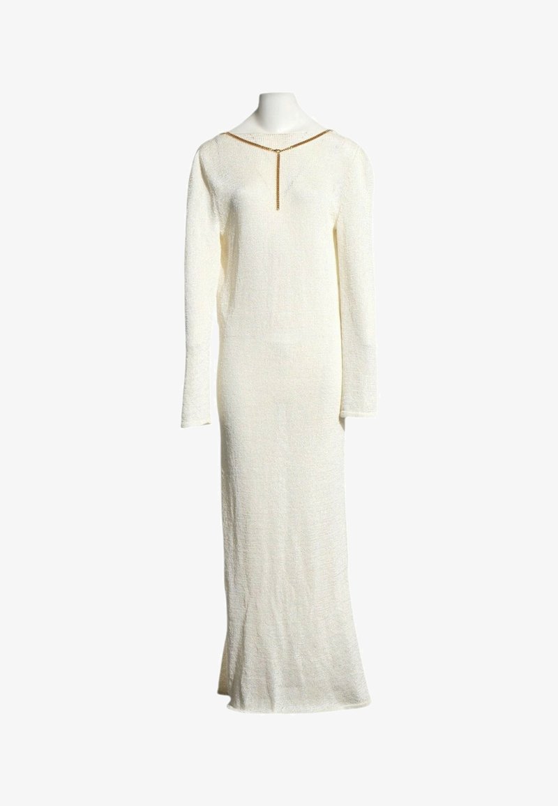 Robe blanche en maille à manches longues et longue jusqu'au sol, avec un détail de chaîne dorée au niveau de l'encolure, exposée sur un mannequin.