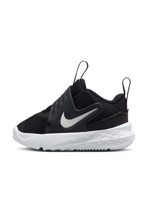 Czarno-białe buty sportowe Nike z siateczkową cholewką, designem zakładanym, pętelkami do ściągania na języku i pięcie oraz białą, fakturowaną podeszwą.