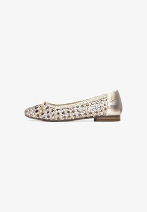 Scarpa piatta intrecciata in beige e argento metallico, con punta rotonda, fiocco decorativo e tacco basso. Texture liscia con motivo dettagliato.