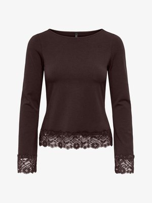 Chemise marron foncé à manches longues avec encolure bateau, ornée de dentelle florale sur l'ourlet et les poignets, présentée sur fond blanc.