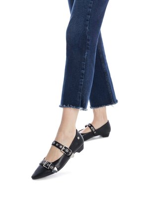 Bailarinas de cuero negro con puntera puntiaguda, que presentan dos correas ajustables con tachuelas metálicas. Tacones bajos y detalles de diseño elegantes.
