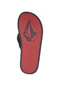 Semelle de sandale en caoutchouc noire et rouge avec une surface texturée rouge et des motifs ondulés, présentant un logo noir prominent au centre.