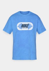 Blå bomulds T-shirt med et centralt grafisk motiv af "NIKE" og "ATHLETIC DEPARTMENT" i sort, omkranset af vægte. Casual design.