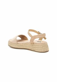 Sandal de esparto beige con suela de yute trenzado, punta abierta y tira en el tobillo. Material suave con una plantilla plana y acolchada.