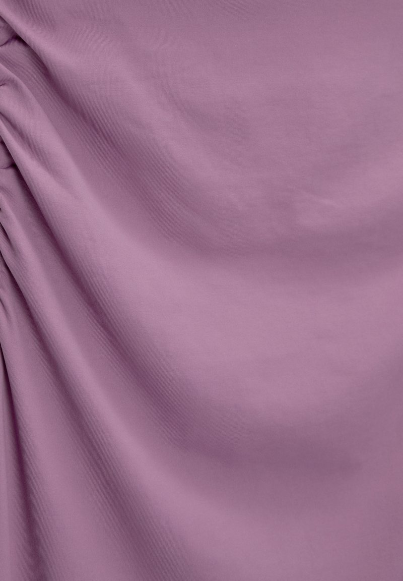 Tissu violet avec une texture douce et lisse, présentant des détails froncés. Le matériau semble extensible et léger, avec un éclat subtil.