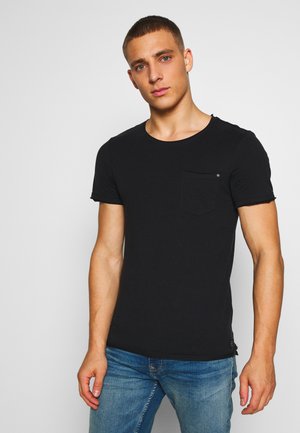 Svart kortärmad T-shirt i mjukt tyg, med rund halsringning och en enkel bröstficka. Designen är minimalisk och åtsittande.