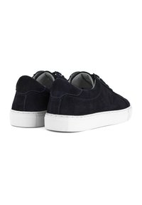 Navy suede sneakers with white rubber soles, rounded toe, and contrasting stitching. Laces and padded heel for comfort and support.
