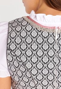 Czarna tkanina z białym wzorem kwiatowym w stylu damask, z różową wstążką na dekolcie i dyskretnym zamkiem z tyłu.