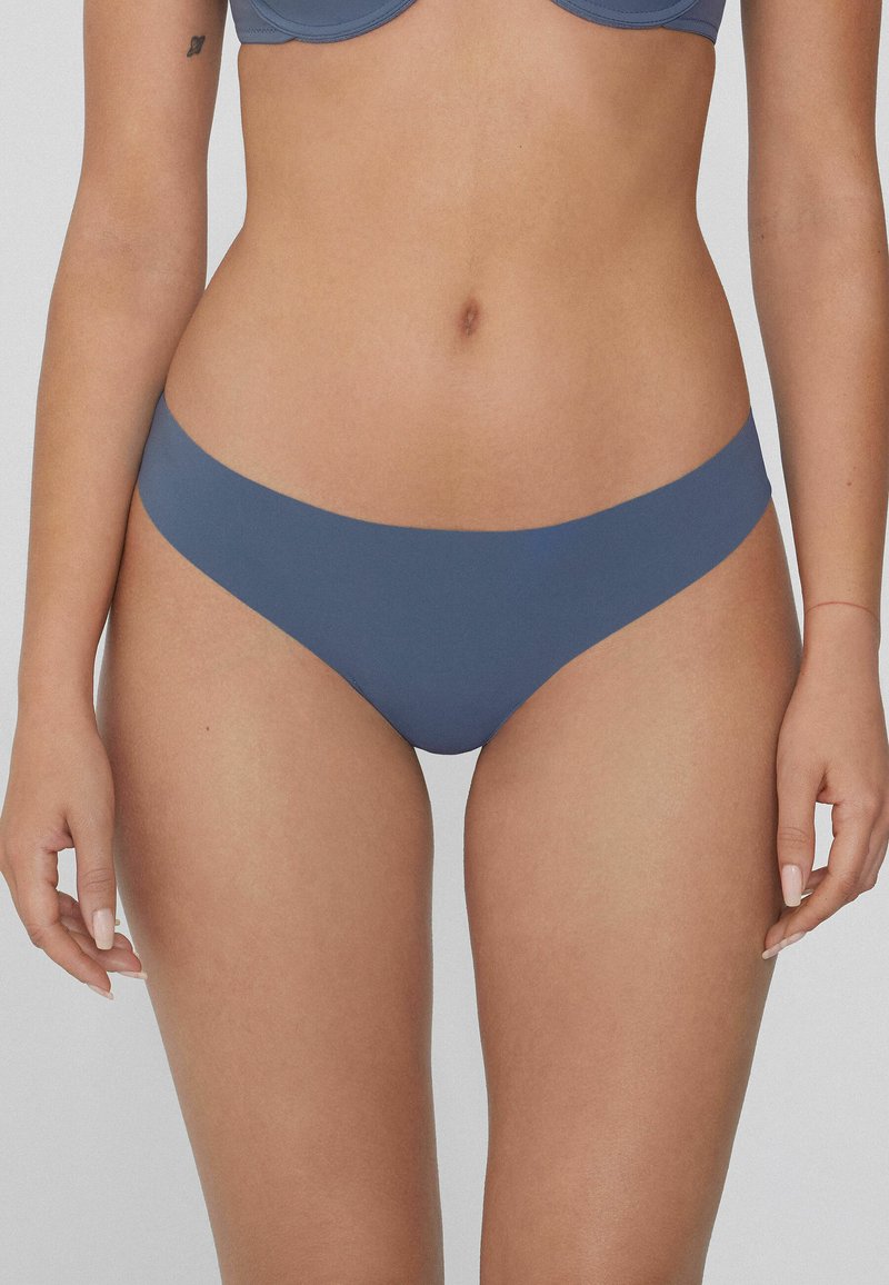 Braguita de bikini azul sin costuras con una textura suave y un diseño de corte bajo, que presenta un estilo minimalista y sin acentos de hardware visibles.