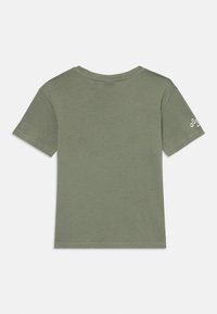 Oliven-grünes Baumwoll-T-Shirt mit rundem Ausschnitt, kurzen Ärmeln und einem kleinen Logo auf dem linken Ärmel. Geschmeidige Textur, lässige Passform.