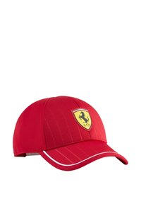 Czerwona czapka baseballowa w pionowe paski, z żółtą tarczą z czarnym koniem oraz białymi akcentami wzdłuż daszka.