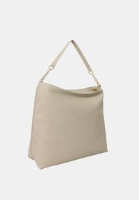 Borsa in pelle beige con una forma morbida, una maniglia superiore singola e inserti in catena dorata. Presenta una superficie testurizzata e un design minimalista.