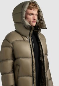 Puffer jacket in olive green, made of shiny fabric, featuring a large hood, quilted pattern, and front zipper with an inner pocket.