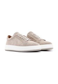 Sneakers in suede beige con suola in gomma bianca, caratterizzati da punta rotonda, chiusura con lacci e design minimalista. Texture liscia in tutto il prodotto.