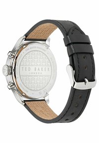 Stainless steel watch with a black leather strap and tan underside. Notable patterned dial with a silver logo and water resistance detail.