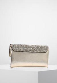 Metallinen hopeinen laukkukotelo, jossa on röpelöinen pohja ja kimaltava käännettävä läppä. Sileä pinta; kompakti suorakulmainen muoto.