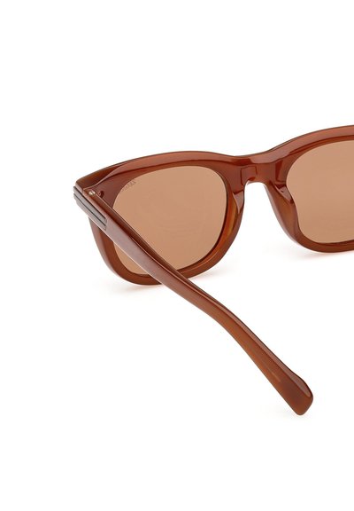 Ruskeat muoviset aurinkolasit, joissa on vintage-henkinen kissansilmämuoto, ruskeat linssit ja tyylikäs, sileä viimeistely. Hillityt metalliset yksityiskohdat sankoissa.