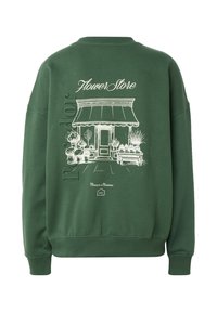 Grøn hættetrøje med hvid skitse af blomsterbutikfacade, planter og teksten "Flower Store," "Moments to Memories," og "OPEN" skilt.