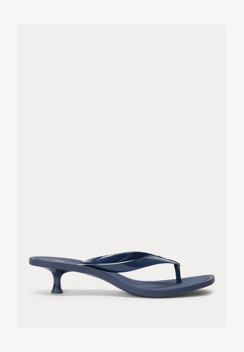 Marineblå hælflip-flop med teksturert fotseng og tynn, buet stropp, vist på hvit bakgrunn.