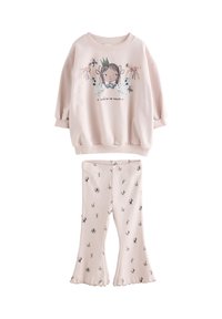 Sweat-shirt rose clair avec un motif d'une fille, comprenant des manches courtes bouffantes et des accents floraux. Pantalon évasé assorti avec de délicats motifs floraux.
