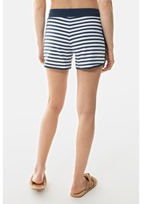 Navy en witte gestreepte katoenen shorts met een aansluitende tailleband, voorzien van een geschulpte zoom en een soepele textuur, gecombineerd met geweven sandalen.