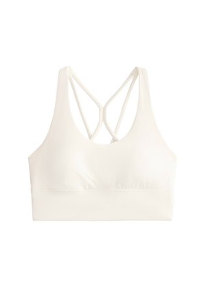 Cremefarvet sports-BH med en glat tekstur, der har en rundudskæring og krydset rygstropper for støtte. Elastisk bånd nederst.