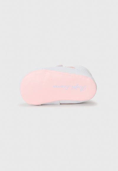 Semelle de chaussure blanche avec un dessous lisse rose et un texte en relief ; design épuré avec des bords arrondis et sans motifs visibles.
