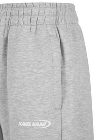 Pilkos medvilninės laisvalaikio kelnės su elastine juosmens juosta, šoninėmis kišenėmis ir balta "KARL KANI" logotipu ant šlaunies. Lygus audinys.