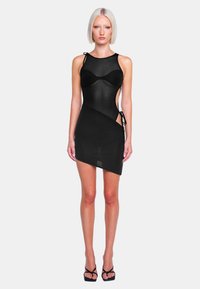 Schwarzes ärmelloses Minikleid aus durchsichtigem Material, asymmetrischem Design, seitlichen Ausschnitten und verstellbaren Bindebändern an den Schultern.
