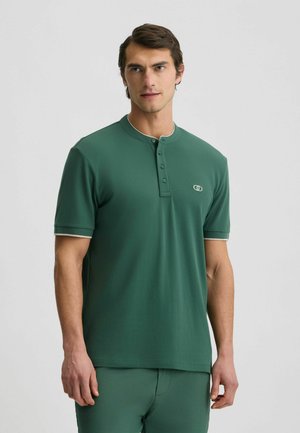 Grünes Kurzarm-Polohemd aus glattem Stoff. Verfügt über eine Knopfleiste, kontrastierenden hellen Kragen und Ärmelabschlüsse sowie Logo-Details.