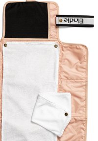 Rosa vadderad skötmatta med en mjuk vit handduk, svart överdel och ett randigt svart- och vitt rem med en logotyp.