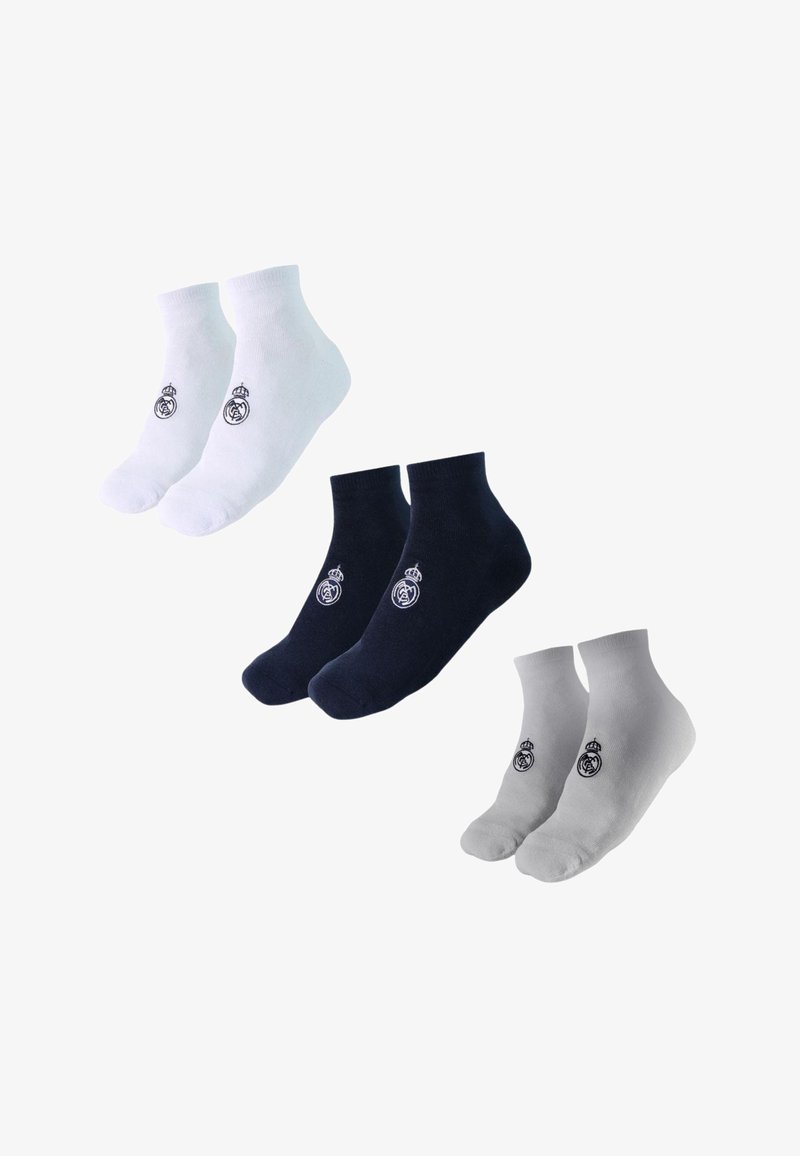 Trois paires de socquettes aux chevilles en blanc, noir et gris, chacune avec un petit logo circulaire brodé près de la cheville.