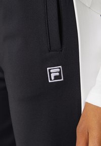 Fila RADIA TAPERED TRACK PANTS - Calças de fato de treino - black/bright white