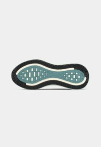 Črna in teal športna obutev s podplatom z vzorčastim profilom in belimi ukrivljenimi žlebovi na navadni beeli podlagi.