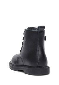 Zwarte leren enkelboot met een ronde neus, veter sluiting aan de voorkant en contrasterende blauwe stiksels. Duurzame rubberen zool voor extra grip.