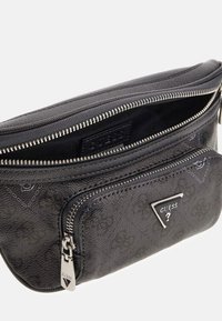 Bolso cruzado negro texturizado con un zipper plateado. Presenta un bolsillo con zipper en la parte frontal y un acento de logo triangular.