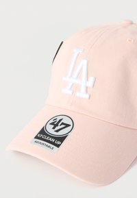 Καπέλο μπέιζμπολ, ύφασμα ανοιχτού ροζ χρώματος, κεντημένο λευκό λογότυπο "LA", ρυθμιζόμενο λουράκι, υφή στην επιφάνεια, μαύρη ετικέτα με λευκή εκτύπωση.