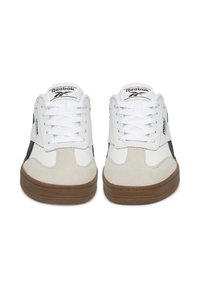 Białe i szare sneakersy z zamszu i skóry, posiadające brązową gumową podeszwę, białe sznurówki oraz czarny akcent po bokach.