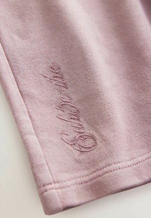 Helles, pinkes Gewebe mit einer weichen Struktur, das dezente bestickte Details aufweist. Glatte Oberfläche mit einem sauberen Saum und einfachem Design.