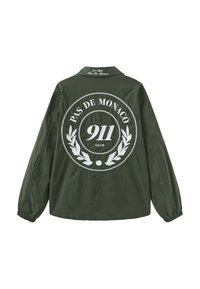 Ciemnozielona kurtka z nadrukiem białego napisu "PAS DE MONACO 911 CLUB" oraz gałązki laurowej na plecach i kołnierzu, długie rękawy z elastycznymi mankietami.