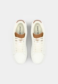 Bijele tenisice s glatkom teksturom, s smeškim kožnim detaljom na peti i ravnim vezicama, s markom "JACK & JONES" na jeziku.