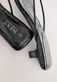 Schwarze, hochhackige Sandalen mit Krokodilmuster, quadratischer Spitze, Slingback-Riemen und "NEXT Forever Comfort"-Markenlogo innen. Größe 6 1/2 oder 40.