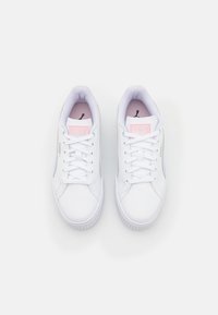 Białe sportowe buty z gładkiej skórzanej cholewki, okrągłym noskiem i płaską podeszwą. Wyposażone w różowe akcenty i sznurowanie. Logo PUMA na języku.