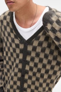 Cardigan în carouri, bej și gri închis. Fabricat dintr-un material moale, având guler în V, nasturi pe față și o croială lejeră.