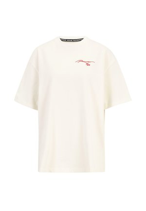 Krēmkrāsas kokvilnas t-krekls ar īsām piedurknēm, brīva piegriezuma, un sarkanu grafisku apdruku, kas satur tekstu "Rocaire 99" priekšpusē.