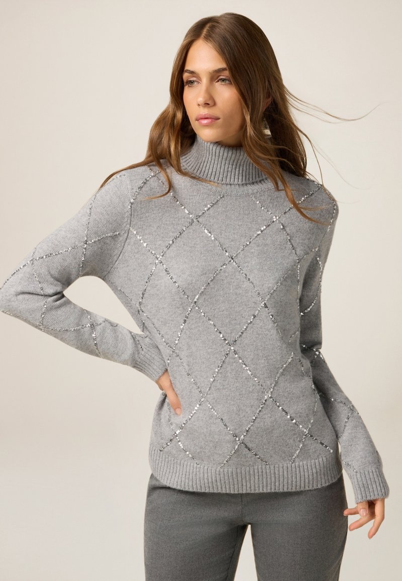 Szary sweter z dzianiny z wysokim kołnierzem, z wzorem srebrnych diamentów i długimi rękawami. Miękka faktura z prążkowanymi mankietami i dolnym wykończeniem.