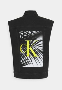 Veste sans manches en denim noir avec un imprimé graphique au dos représentant des ombres de feuilles de palmier et un grand logo "cK" jaune.