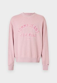 Sarkana džemperis, izgatavots no kokvilnas maisījuma, ar apaļu kakla izgriezumu, nolaižamām plecu daļām un kontrastējošās krāsās drukātu logo "TOMMY JEANS NEW YORK CITY".