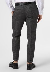 Grå rutiga byxor med slim fit, som har ett subtilt mönster, två bakfickor och ett standard midjeband, kombinerat med svarta skor.